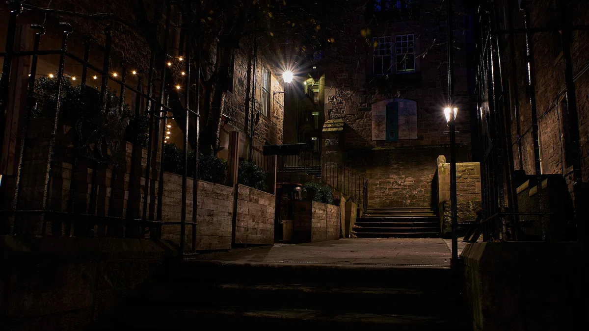 Guide and group among old headstones on an Edinburgh ghost tour at Old Calton Cemetery, Old Town, Scotland