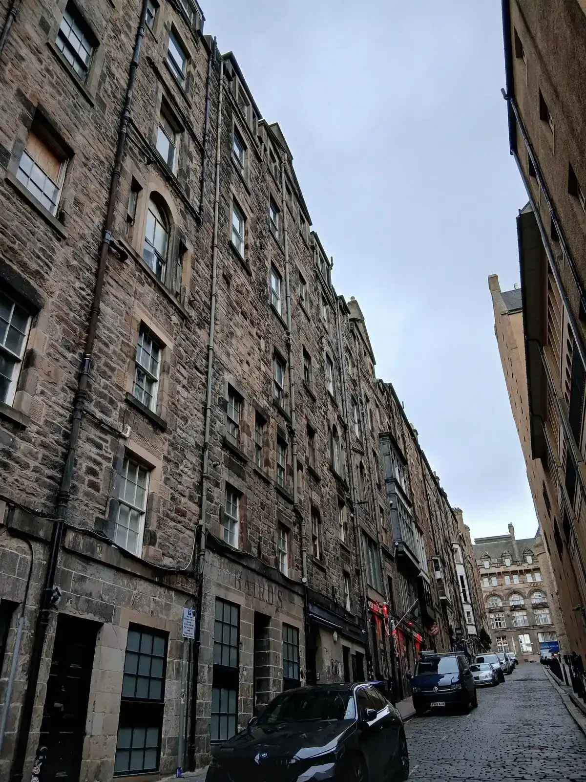Niddry Street dropping steeply between tall stone tenements near the South Bridge vaults, Edinburgh ghost tours, Edinburgh, Scotland